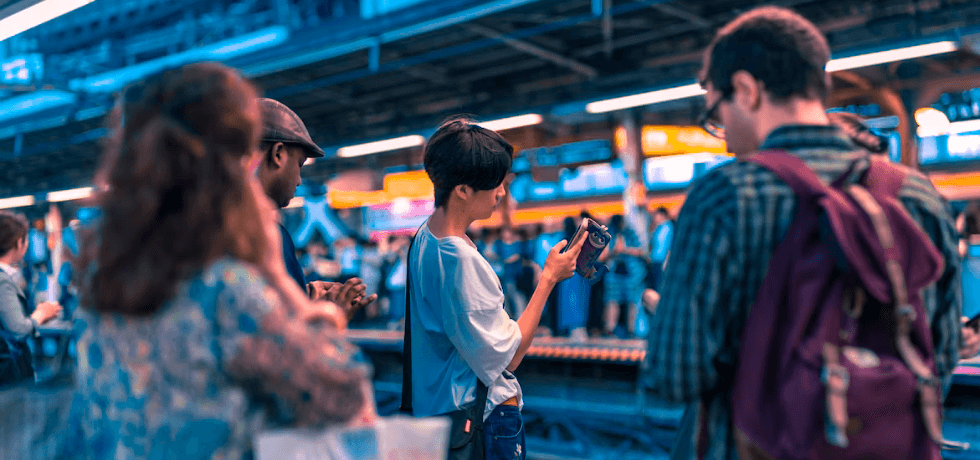 Bulk SMS - People using their phones at a train station